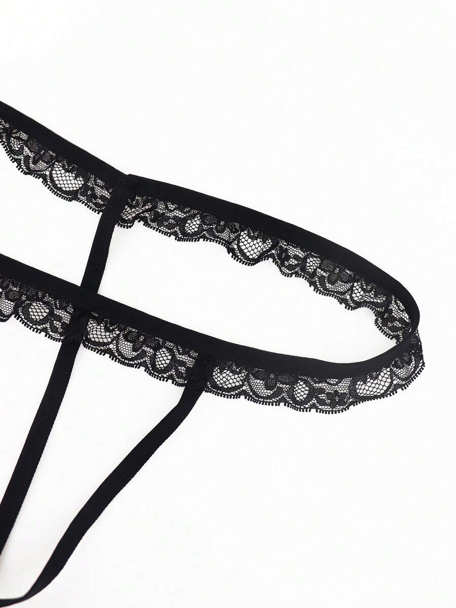 Black men's thong underwear featuring a low rise waist and letter pattern crafted from knitted stretch fabric.
