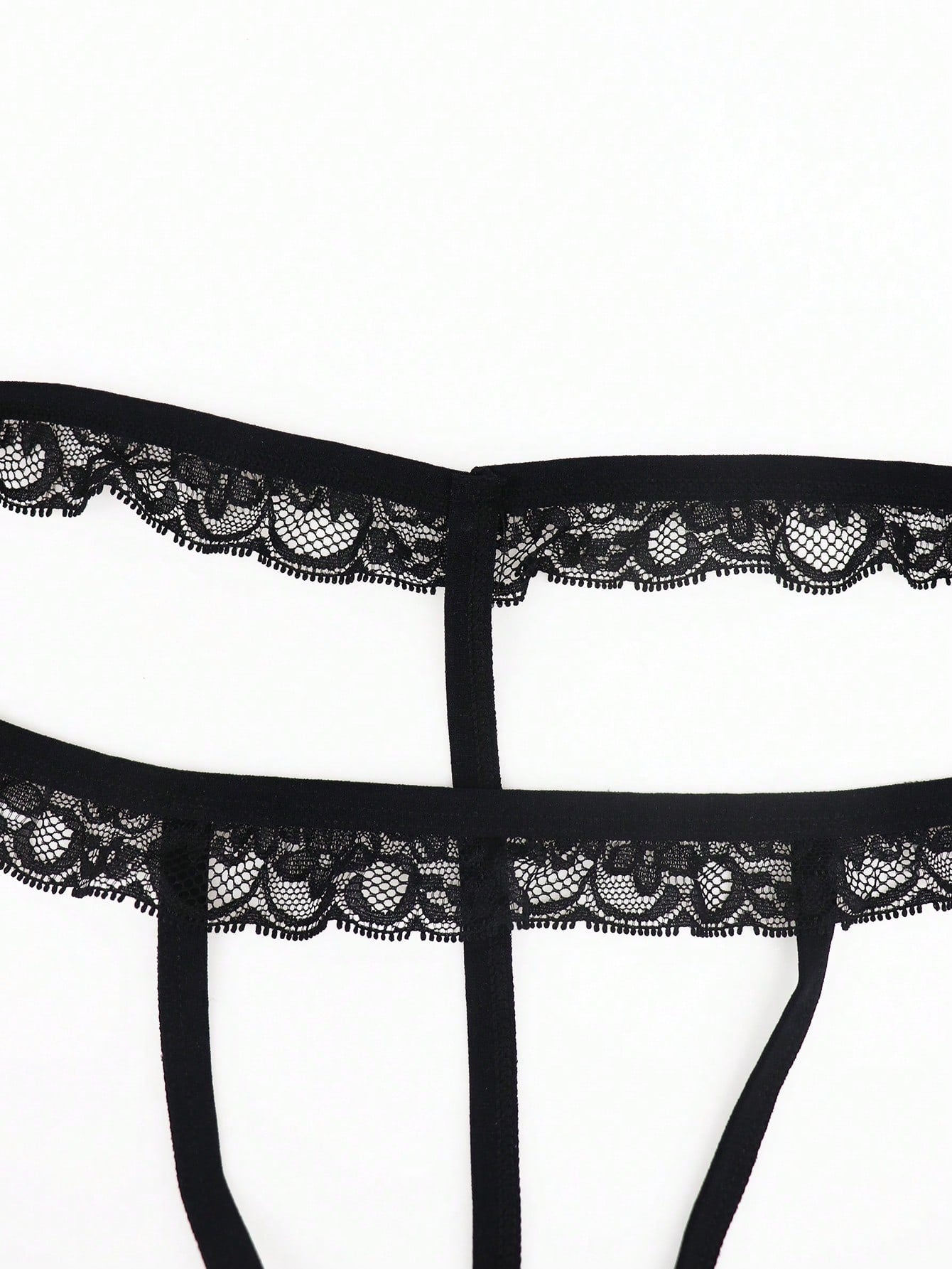 Black men's low rise thong underwear in knitted fabric with lace styling, letter pattern, medium stretch, and a non-sheer finish.