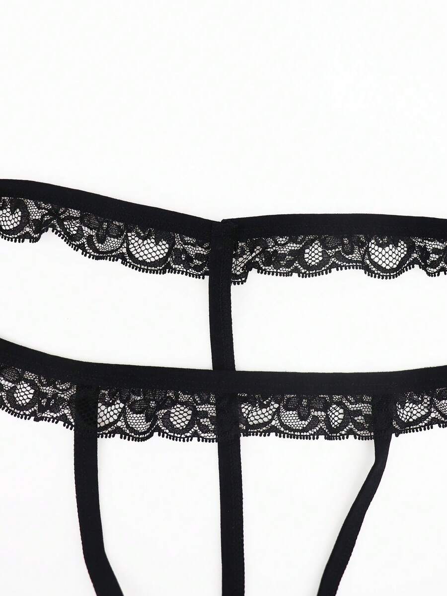 Black men's thong underwear featuring a low rise waist and letter pattern crafted from knitted stretch fabric.