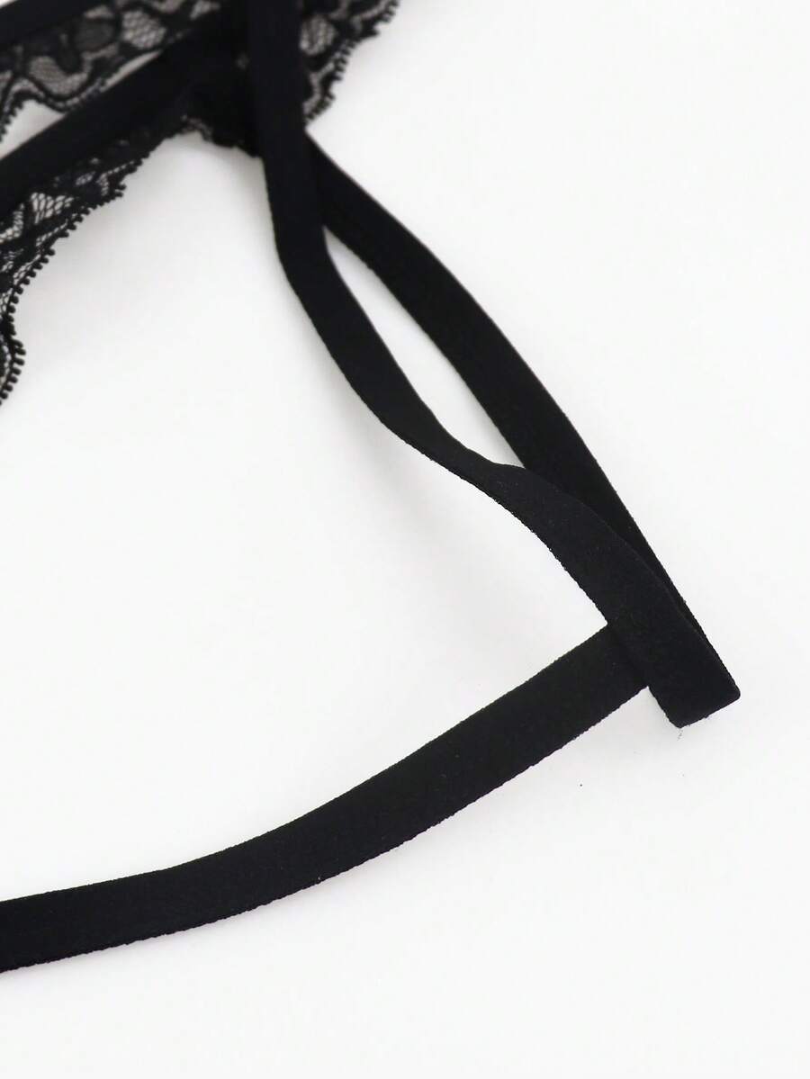 Black men's thong underwear featuring a low rise waist and letter pattern crafted from knitted stretch fabric.