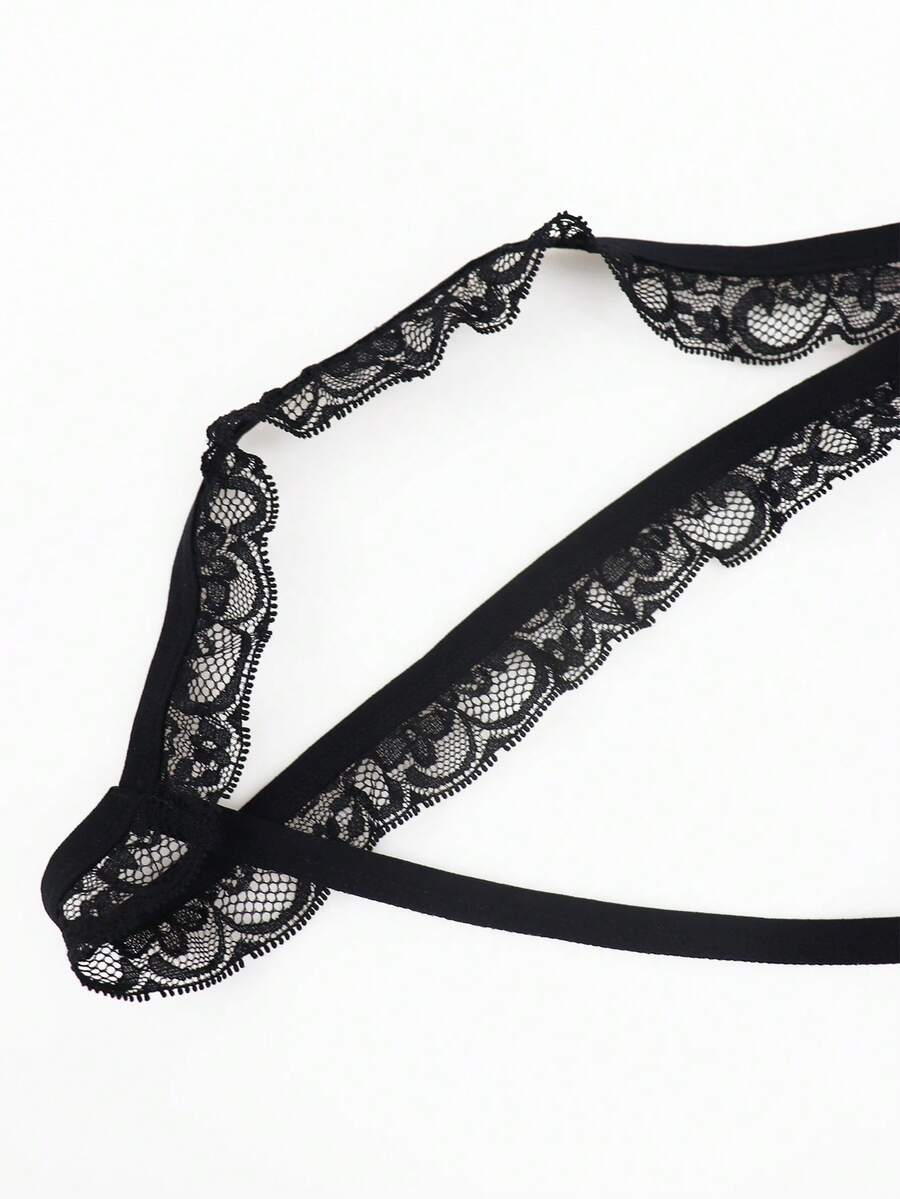 Black men's thong underwear featuring a low rise waist and letter pattern crafted from knitted stretch fabric.