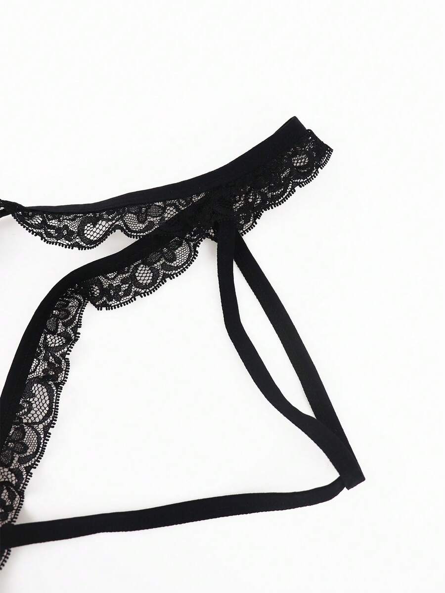 Black men's thong underwear featuring a low rise waist and letter pattern crafted from knitted stretch fabric.