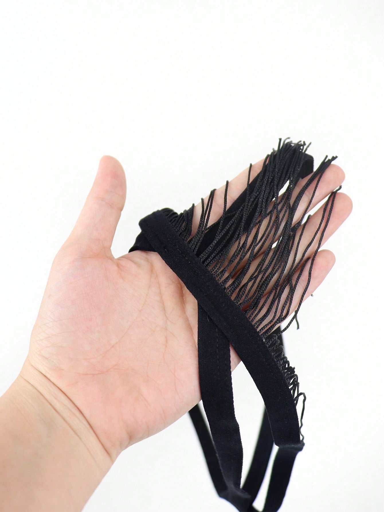 Black men's thong underwear with a low-rise waist, plain design, and knitted stretch fabric.