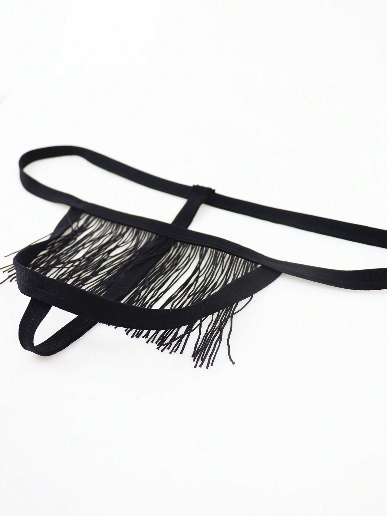 Black men's thong underwear with fringe detail, mid-rise fit, plain design, and knitted fabric construction.
