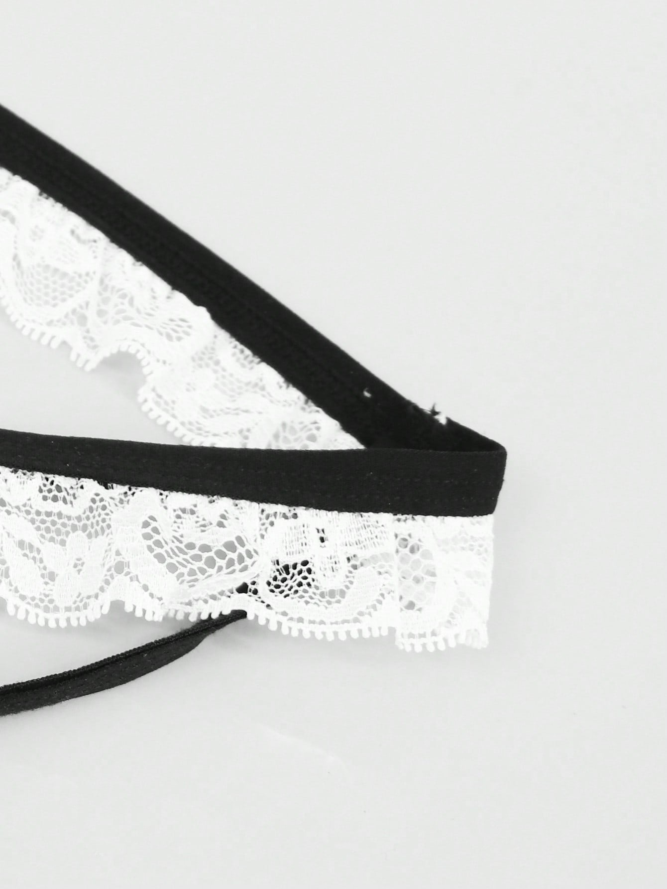 Men's mesh thong underwear with a mid-waist fit and black and white colorblock design.