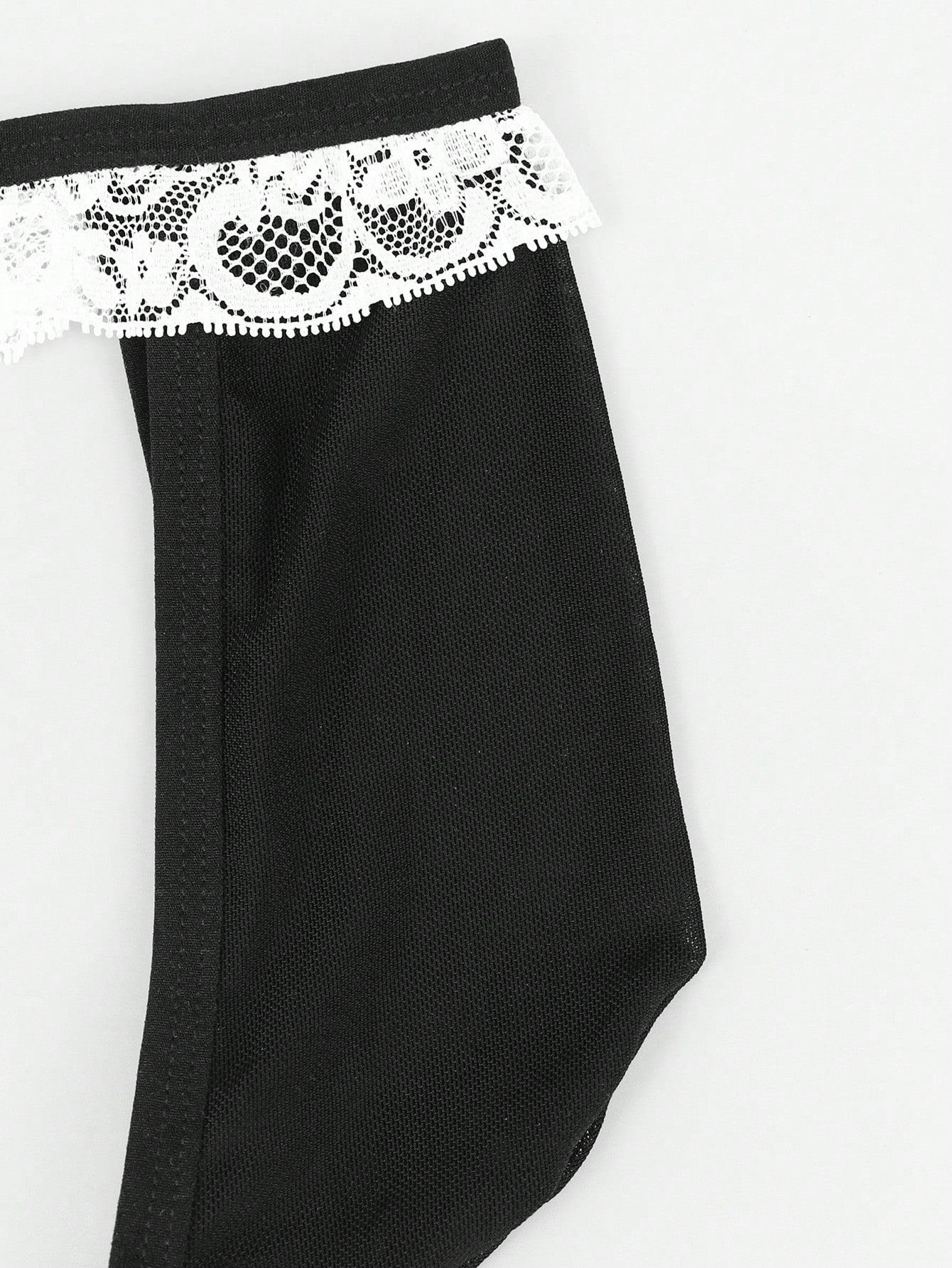 Men's mesh thong underwear with a mid-waist fit and black and white colorblock design.