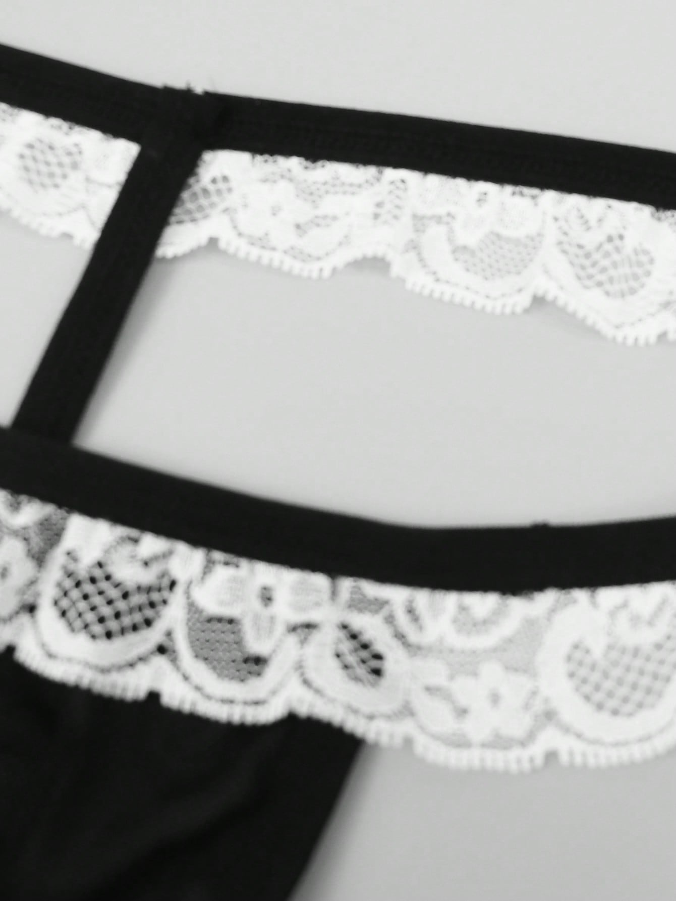 Men's mesh thong underwear with a mid-waist fit and black and white colorblock design.