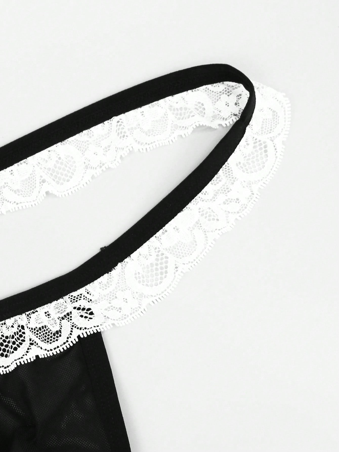 Men's mesh thong underwear with a mid-waist fit and black and white colorblock design.