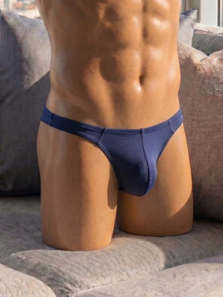 Men's solid color low-rise hollow out thong underwear made of flexible stretch fabric.