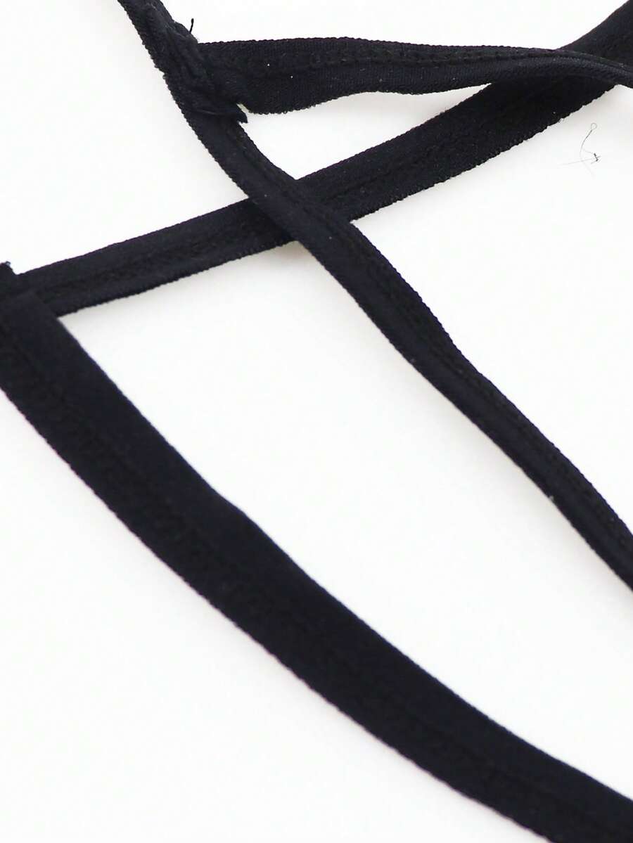 Red low-rise men's mesh thong underwear featuring a colorblock letter waistband and bulge-enhancing front pouch.
