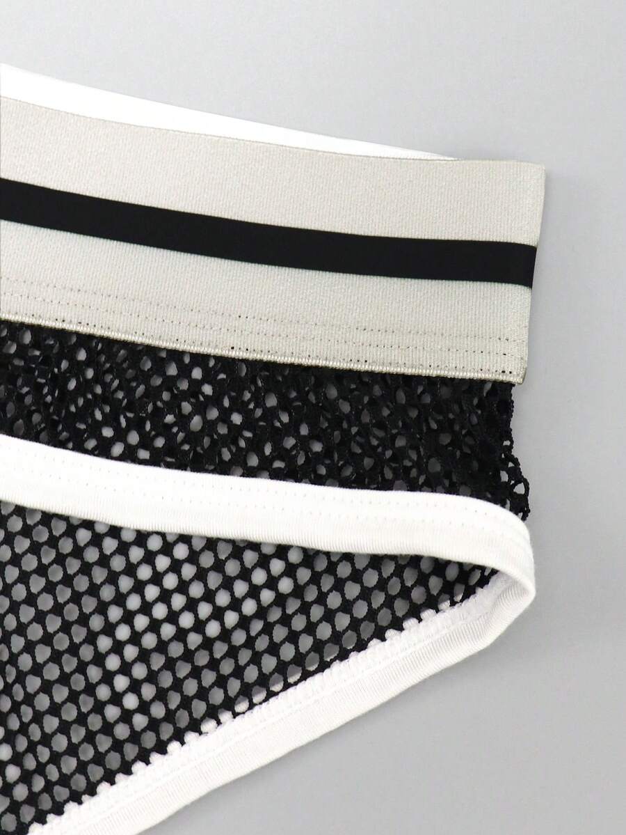 Black low-rise men's mesh briefs featuring contrast binding and tape details