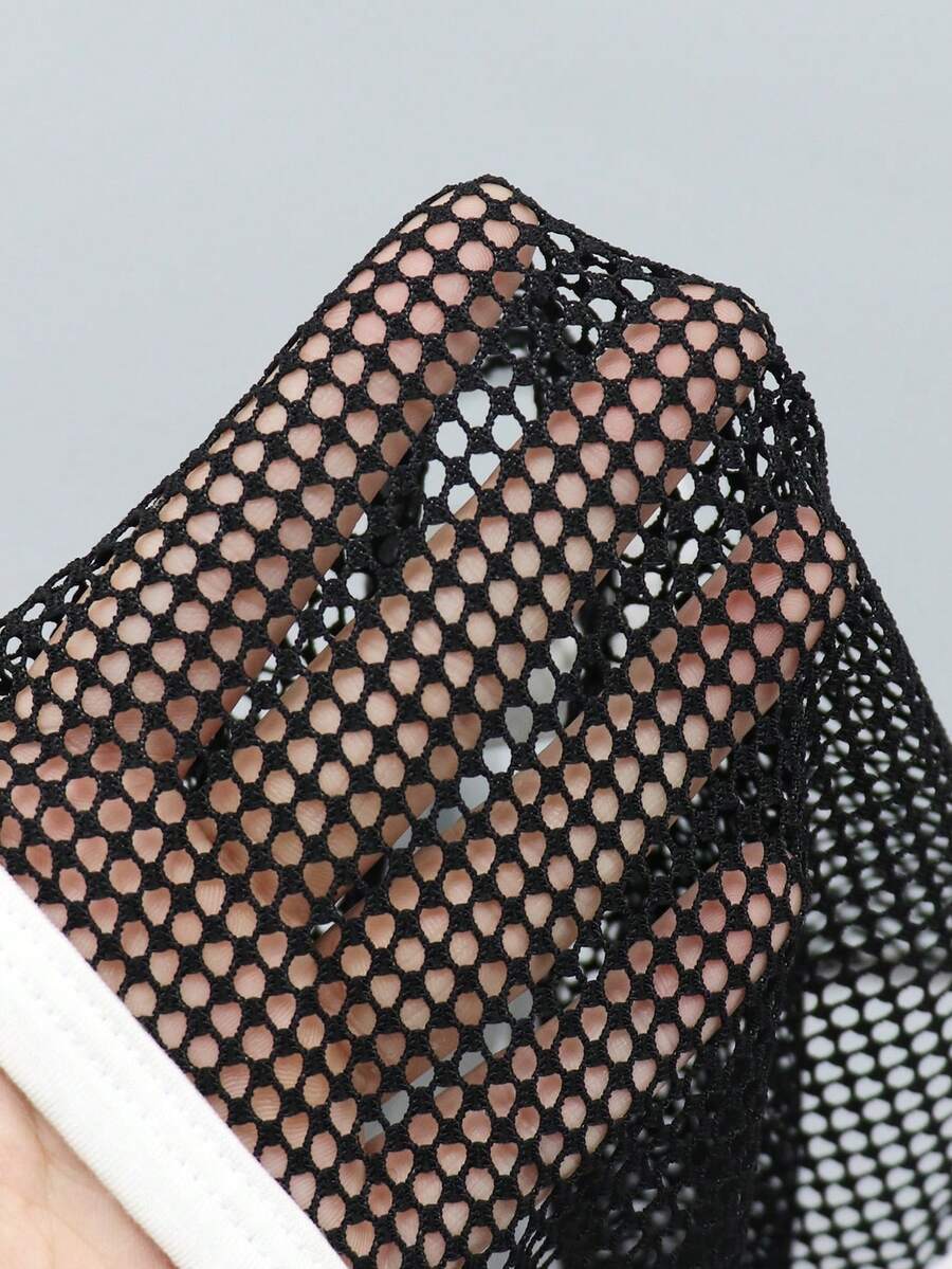 Black low-rise men's mesh briefs featuring contrast binding and tape details