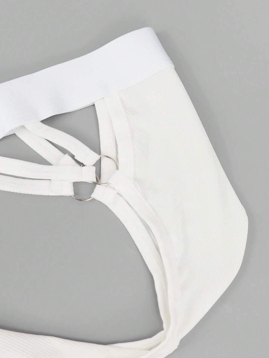 Men's black low-rise thong underwear with a ring-connected hollow design in knitted stretch fabric.