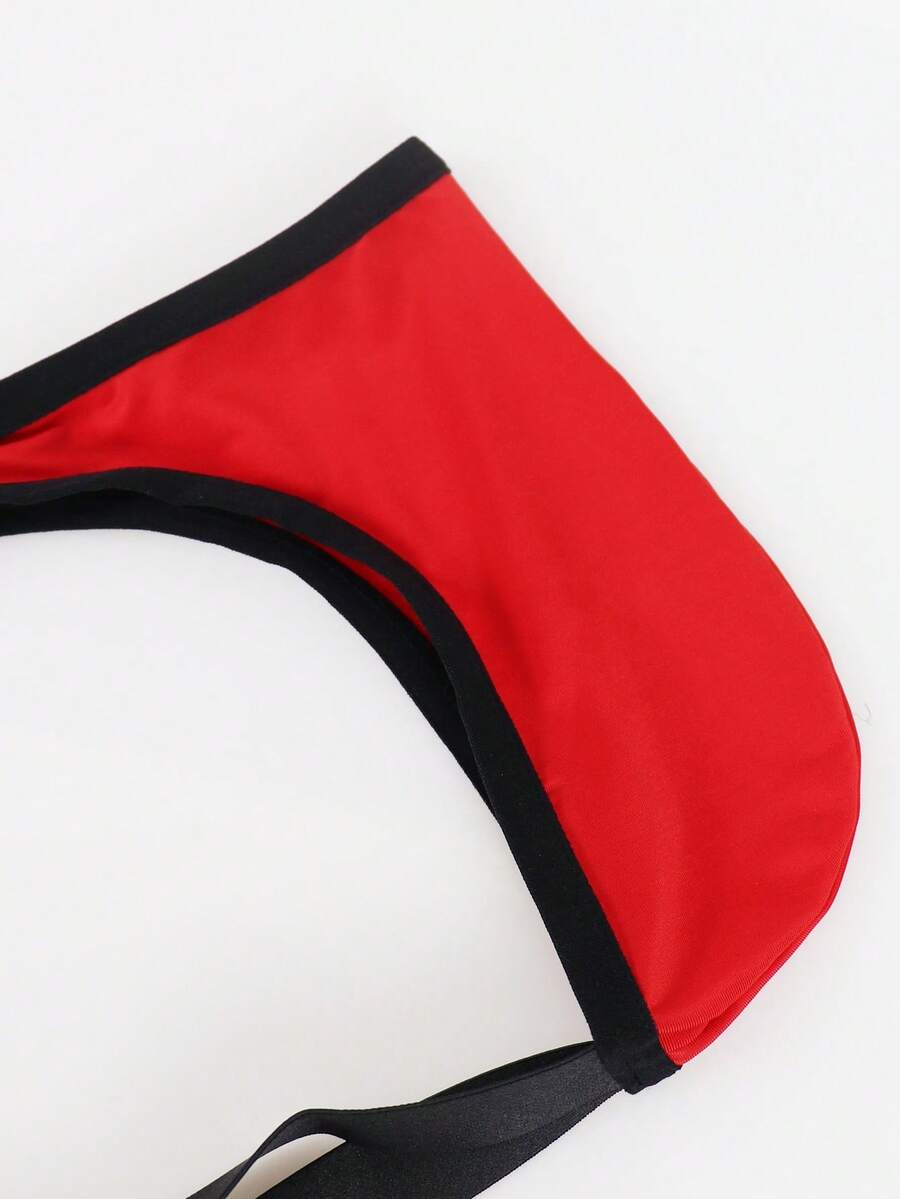 Red men's low-rise jockstrap underwear featuring criss-cross cut-out details in medium stretch knitted fabric.