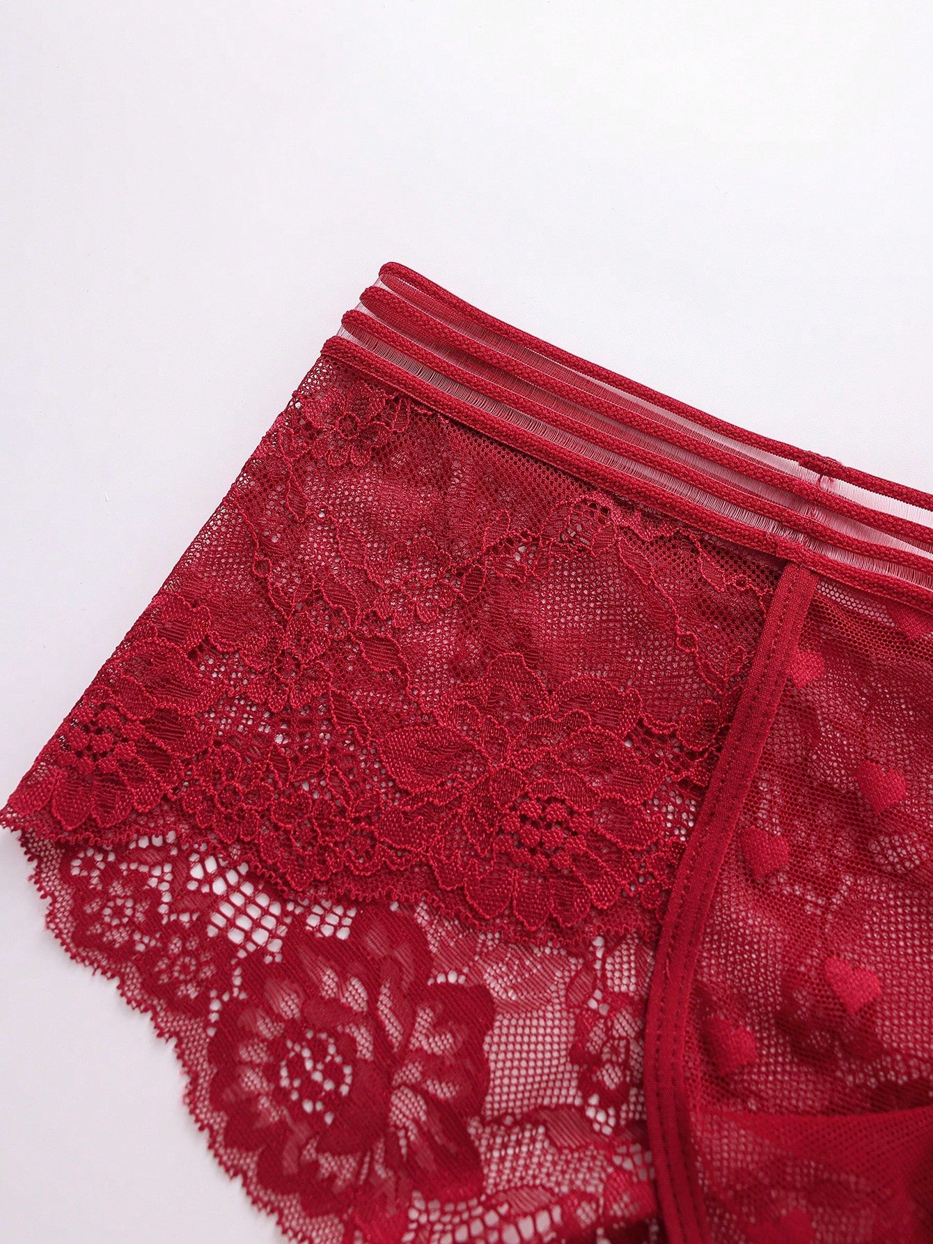 Men's semi-sheer lace briefs in burgundy with a geometric pattern, mid-rise fit, and medium-stretch knitted fabric.