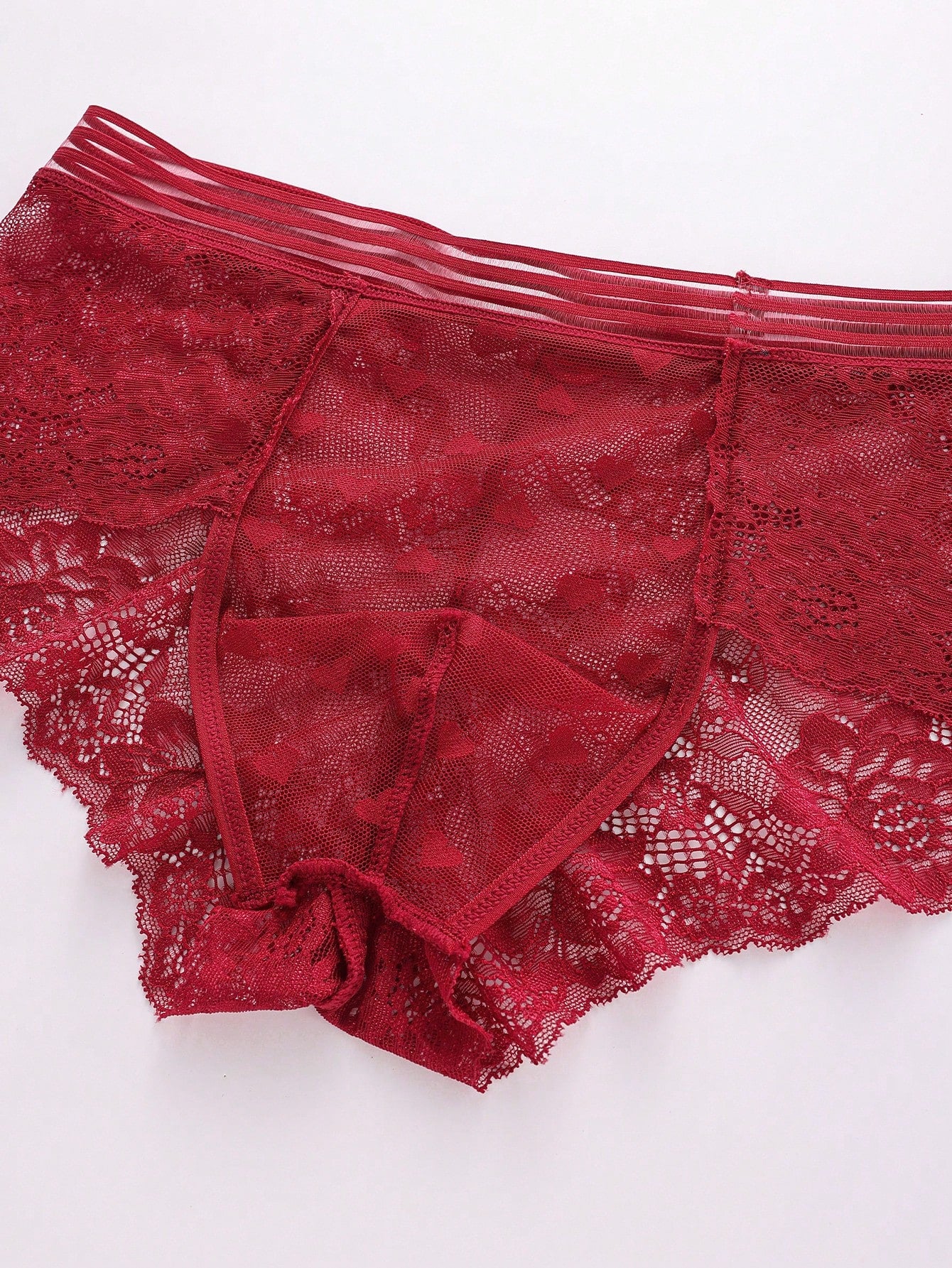 Men's semi-sheer lace briefs in burgundy with a geometric pattern, mid-rise fit, and medium-stretch knitted fabric.