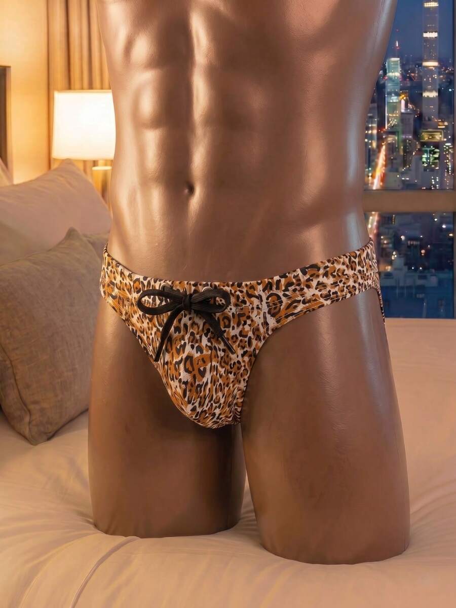 Brown men's leopard print low rise G-string thong featuring a bow accent and textured pattern.