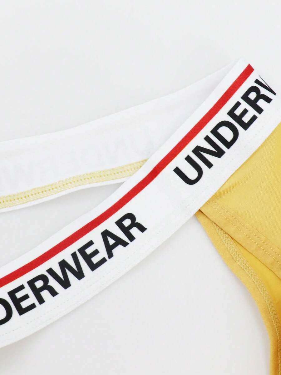 Low rise men's thong underwear with rhinestone letter print detail.