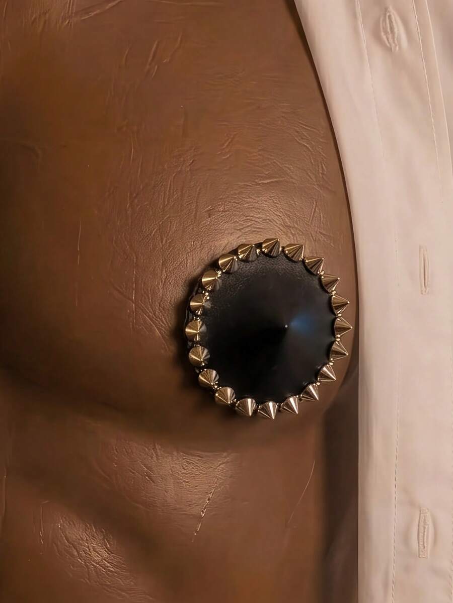 Single black rivet-decorated studded nipple cover for men made of metallic 100% viscose fabric.