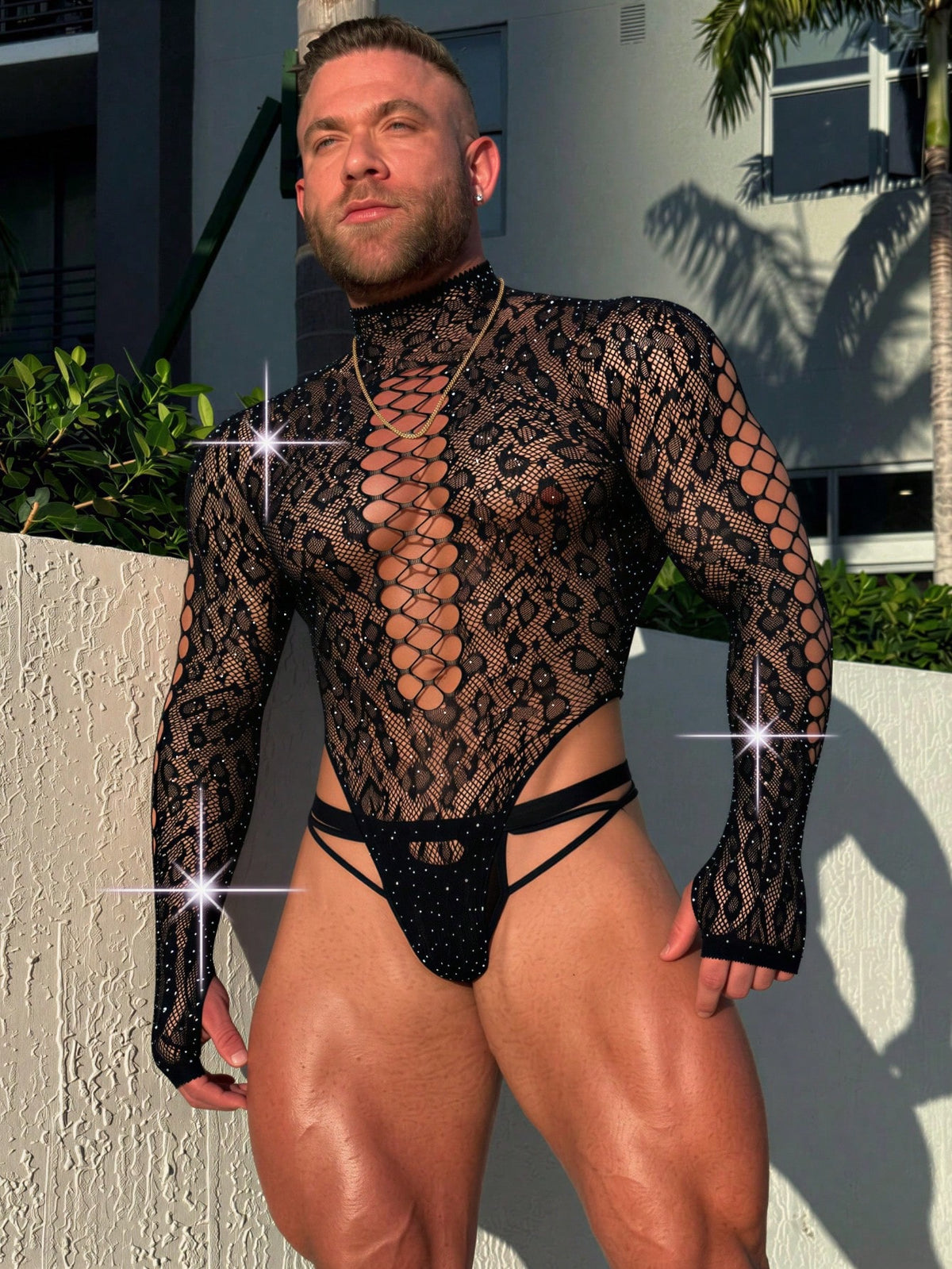 Front view of a men's black sheer hollow-out long jumpsuit featuring a stand collar