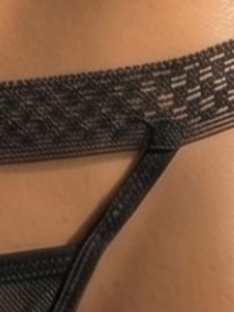 Black hollow mesh thong underwear for men with low rise waist and medium stretch fabric.