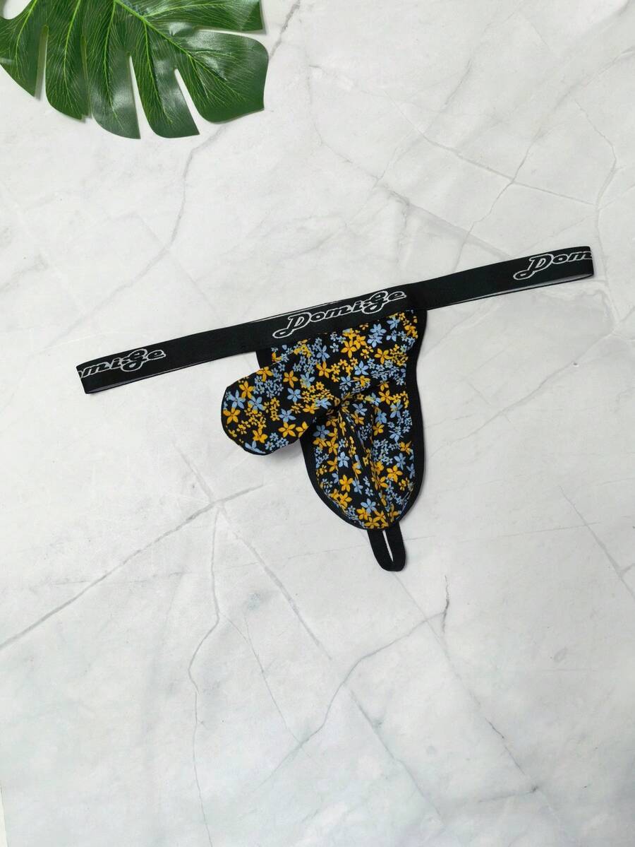 Black and white colorblock low-rise thong underwear for men featuring tape detail and knitted stretch fabric.