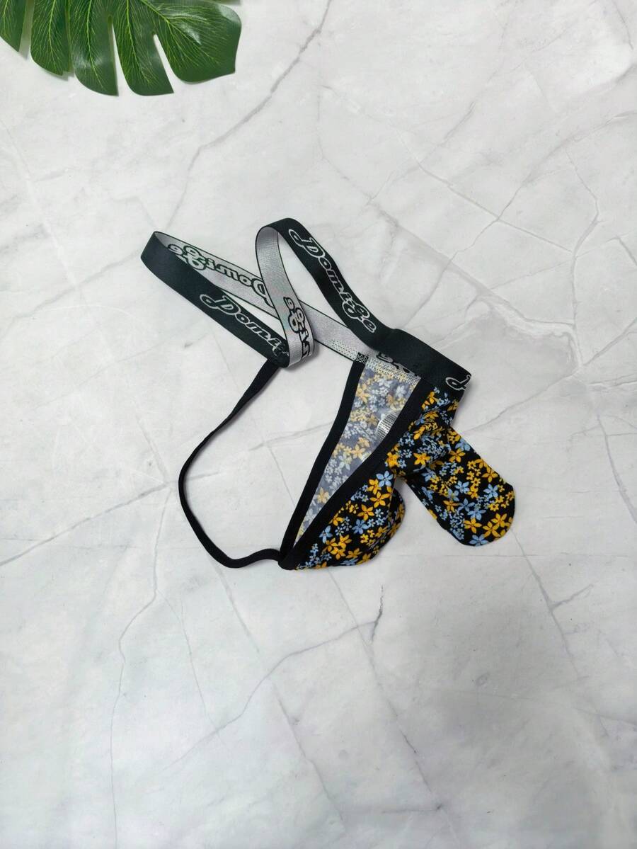Black and white colorblock low-rise thong underwear for men featuring tape detail and knitted stretch fabric.