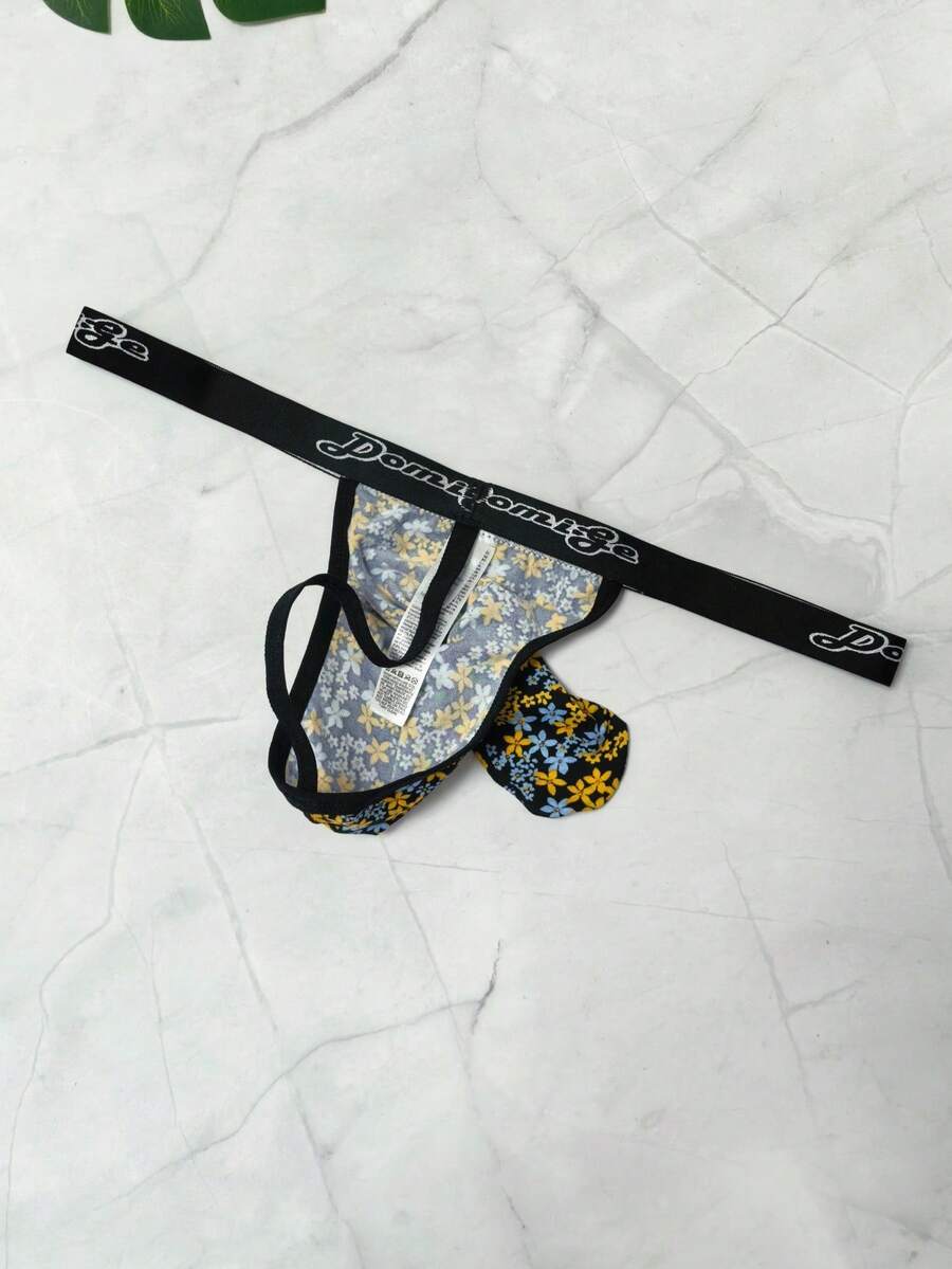 Black and white colorblock low-rise thong underwear for men featuring tape detail and knitted stretch fabric.