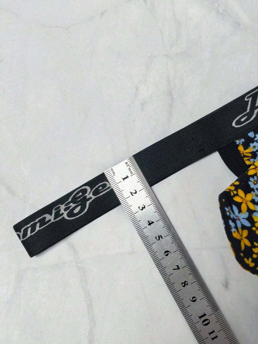 Black and white colorblock low-rise thong underwear for men featuring tape detail and knitted stretch fabric.