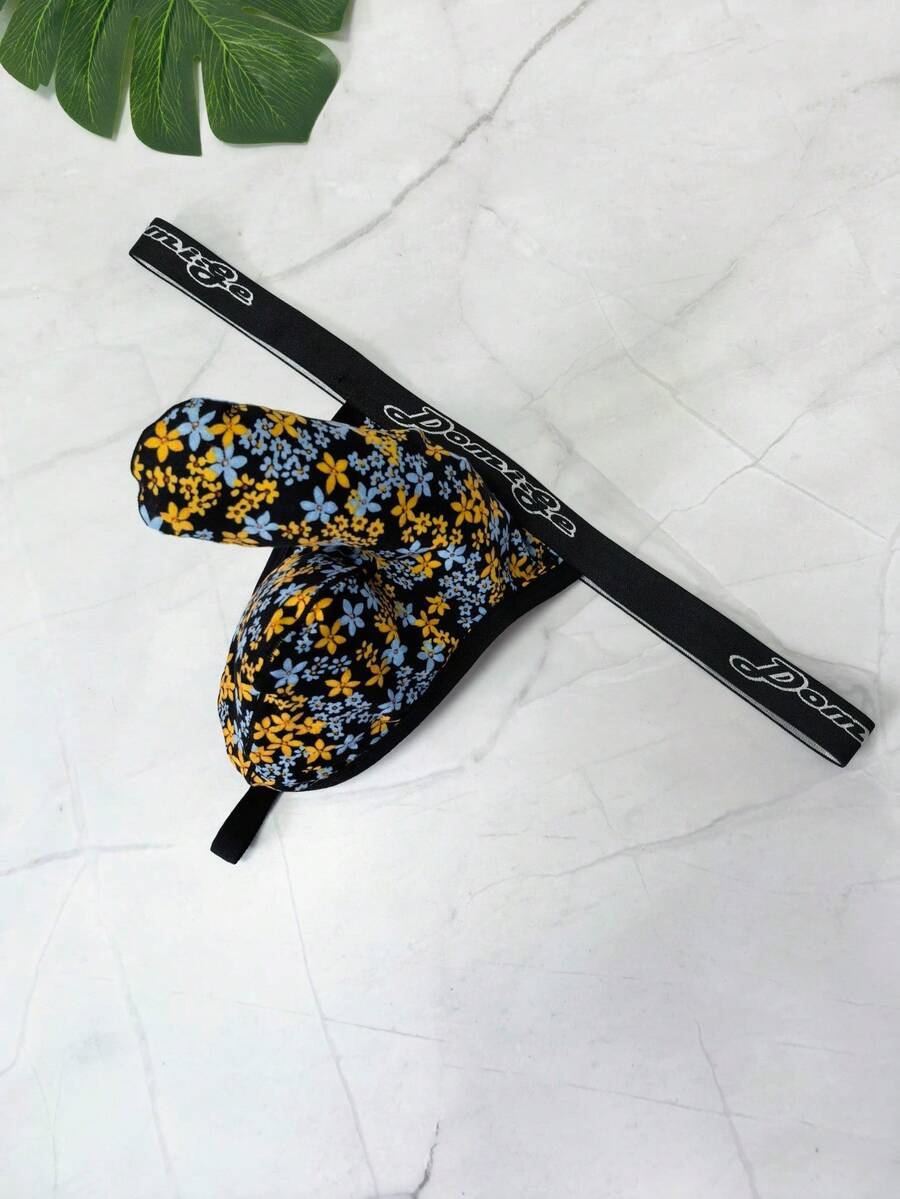 Black and white colorblock low-rise thong underwear for men featuring tape detail and knitted stretch fabric.