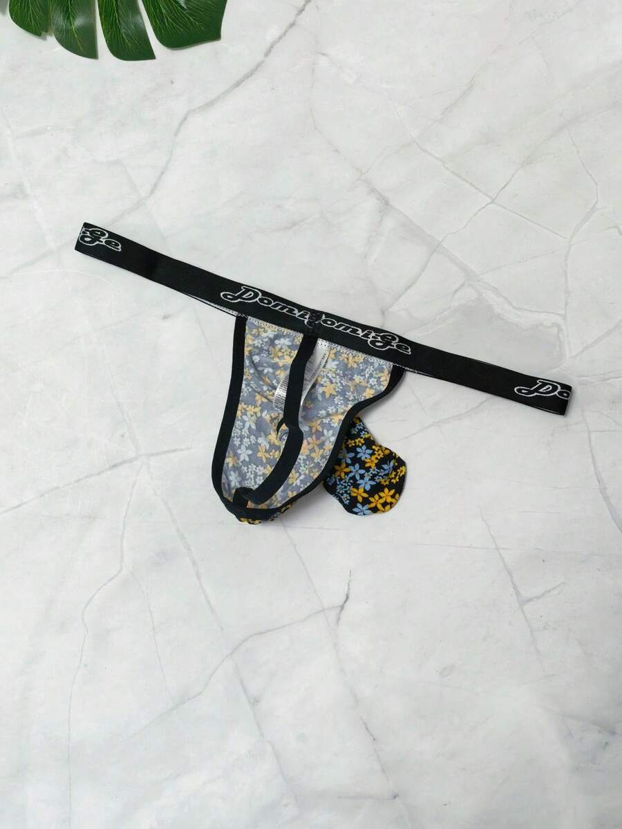 Black and white colorblock low-rise thong underwear for men featuring tape detail and knitted stretch fabric.