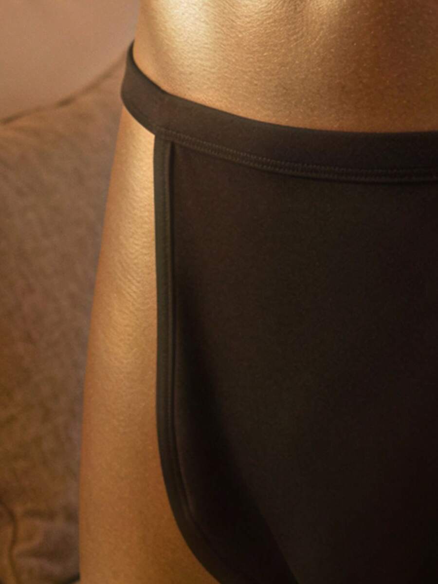 Black low rise men's thong underwear made of stretch knitted fabric