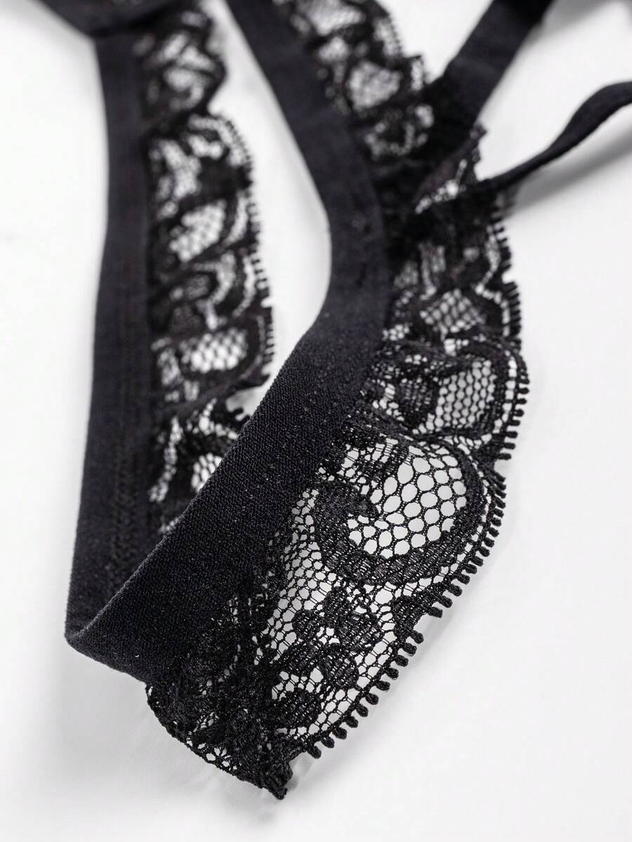 Black low-rise men's thong underwear with bow waist accent made of knitted fabric