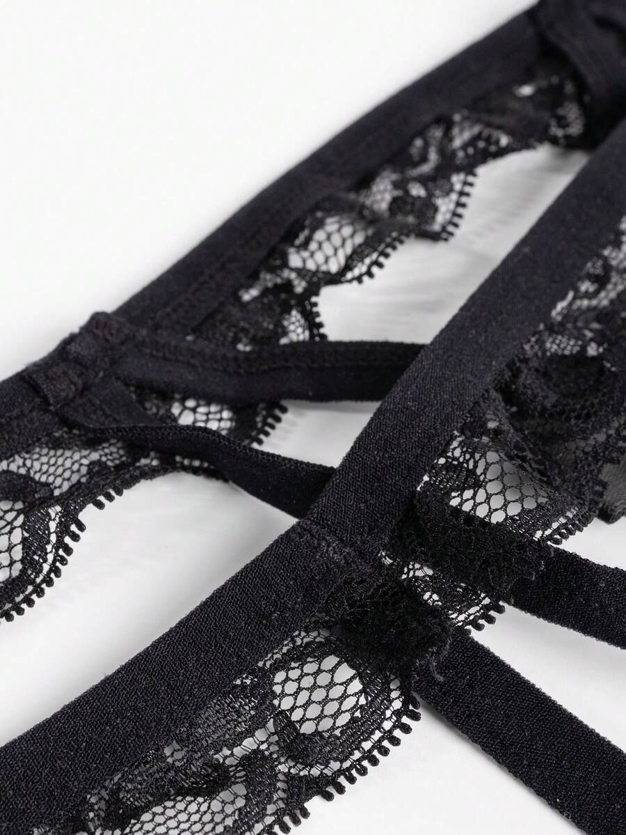 Black low-rise men's thong underwear with bow waist accent made of knitted fabric