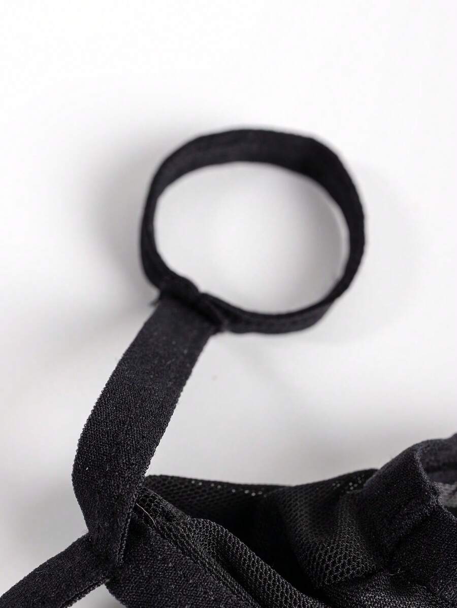 Black men's hollow mesh thong underwear featuring a mid-rise waist and colorblock design.