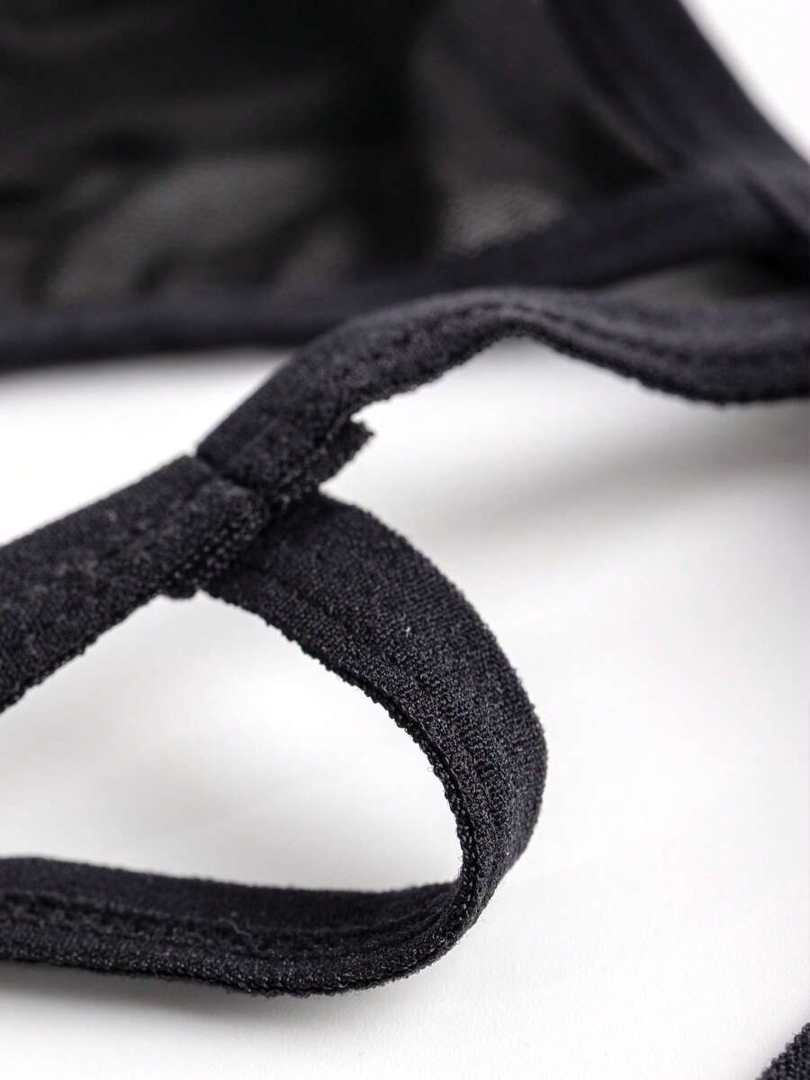 Black men's hollow mesh thong underwear featuring a mid-rise waist and colorblock design.