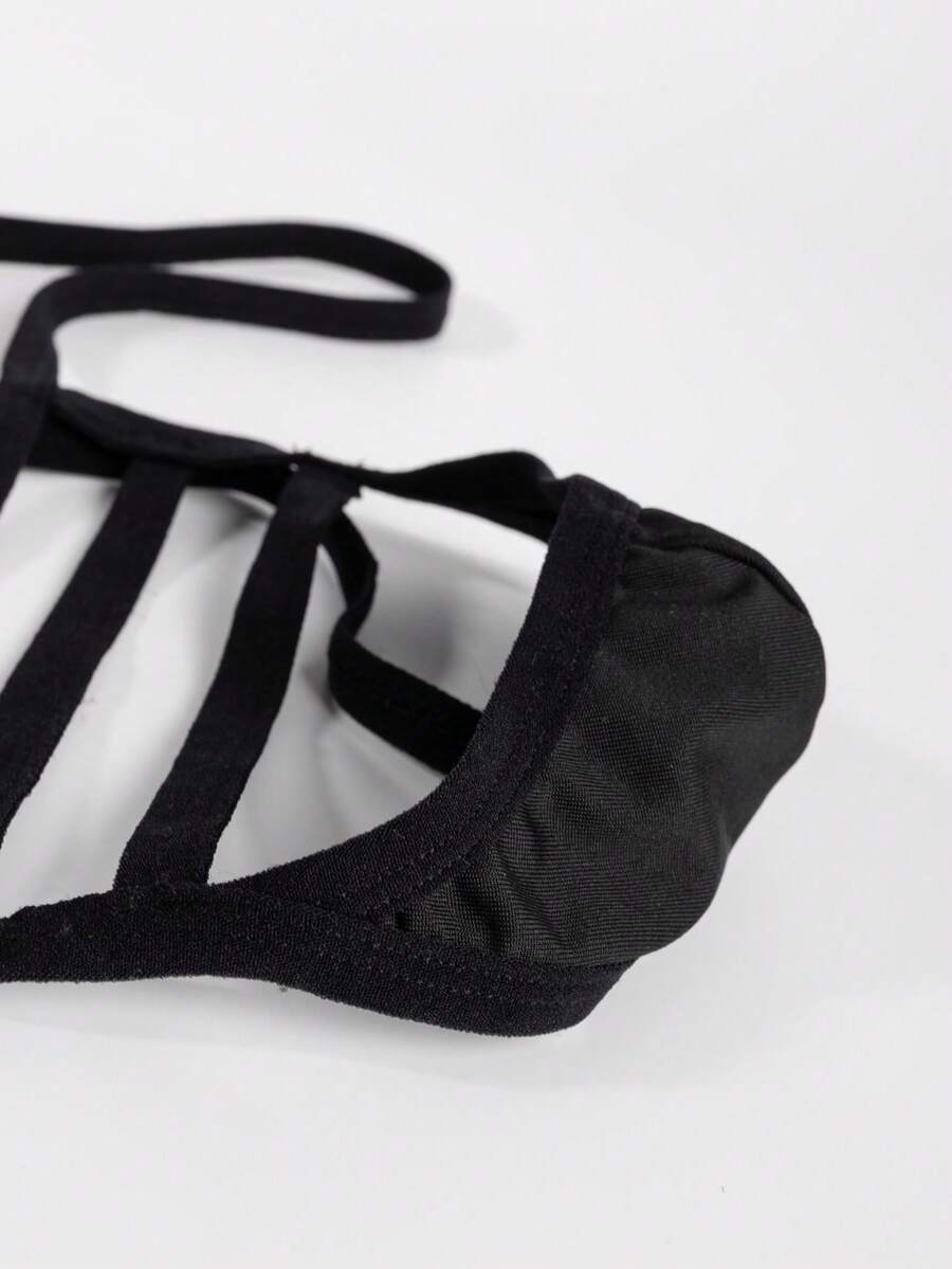 Black low-rise men's T-back thong underwear featuring an anti-slip design made from knitted medium-stretch fabric.