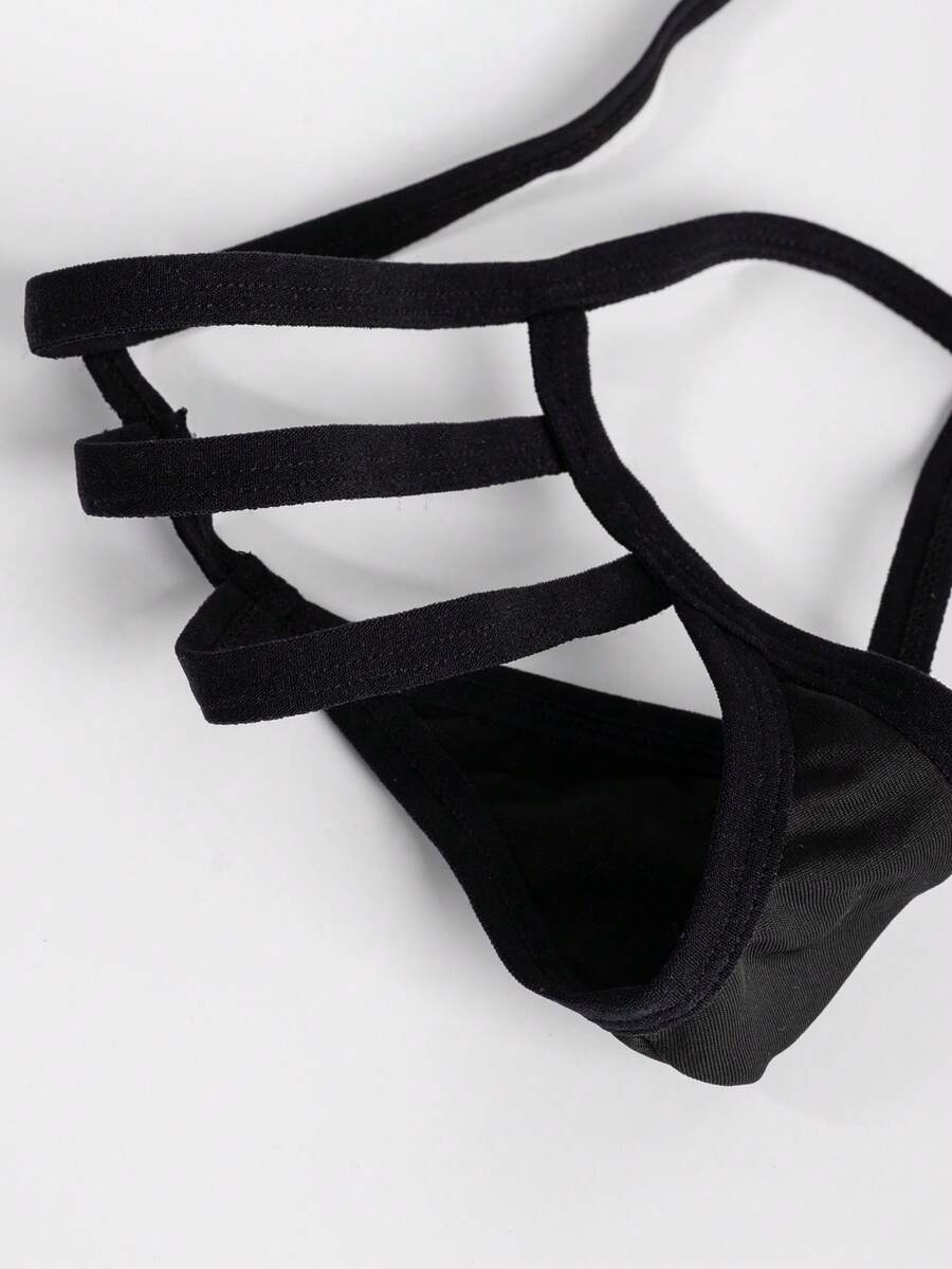 Black low-rise men's T-back thong underwear featuring an anti-slip design made from knitted medium-stretch fabric.