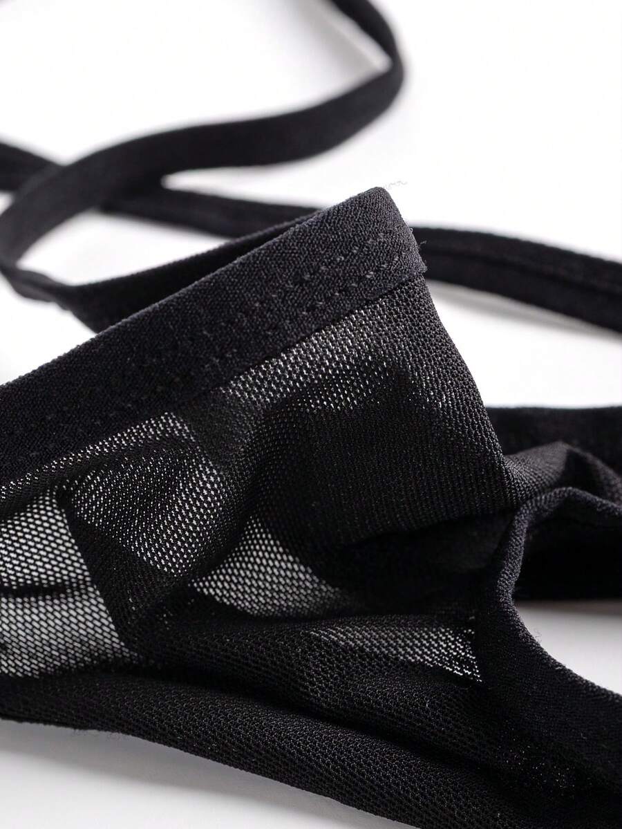 Black men's hollow mesh thong underwear featuring a mid-rise waist and colorblock design.