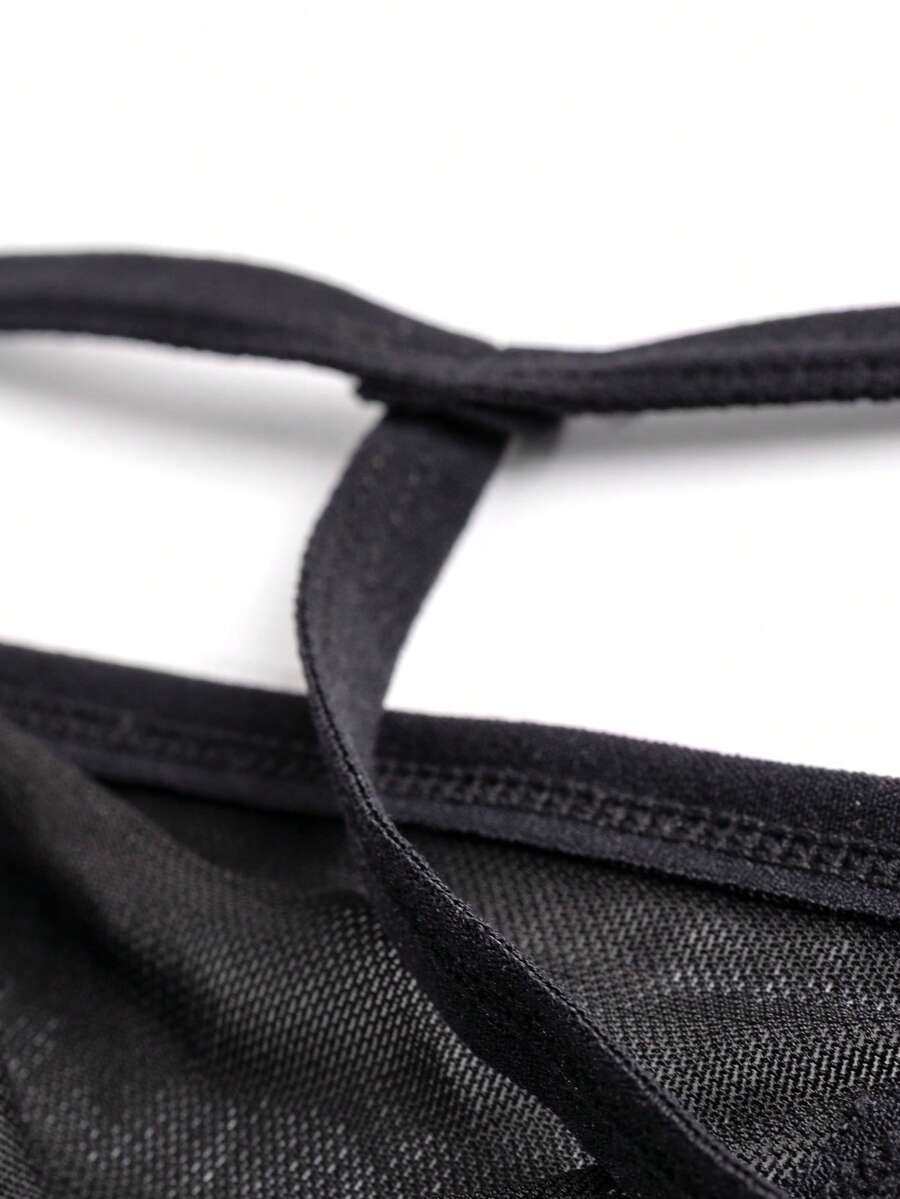 Black men's hollow mesh thong underwear featuring a mid-rise waist and colorblock design.