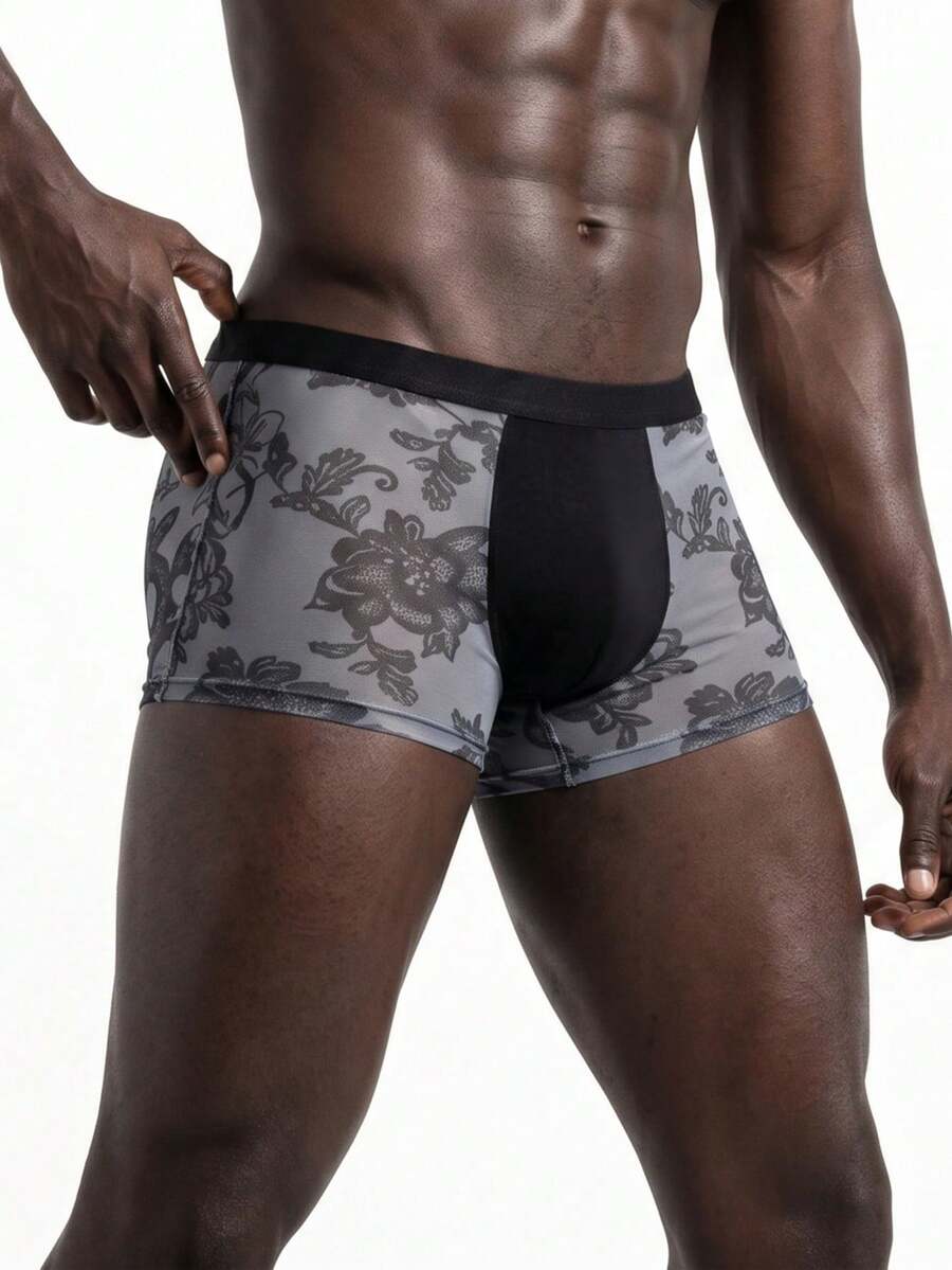 Men's grey low-rise semi-sheer mesh boxer briefs with plant pattern and contrast binding.