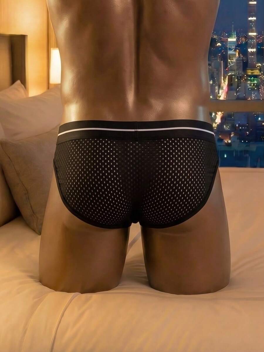 Black men's low rise triangle briefs featuring a colorblock design and letter tape waist detail.