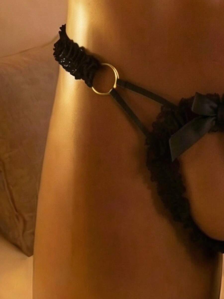 Black men's lace thong featuring low rise V-string styling and front bow detail.