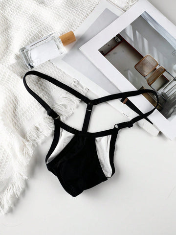 Black low rise men's thong featuring contrast binding detailing and a plain solid design.