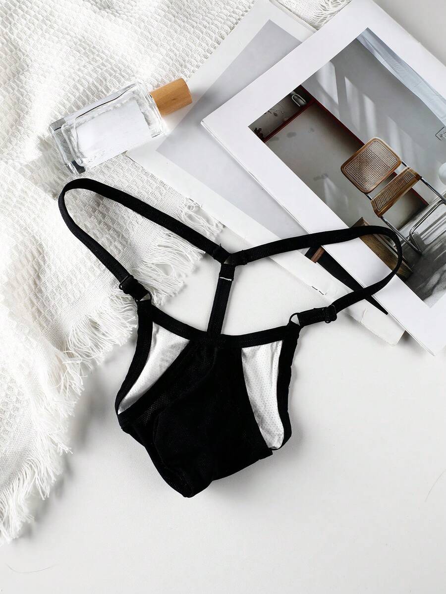 Black low rise men's thong featuring contrast binding detailing and a plain solid design.