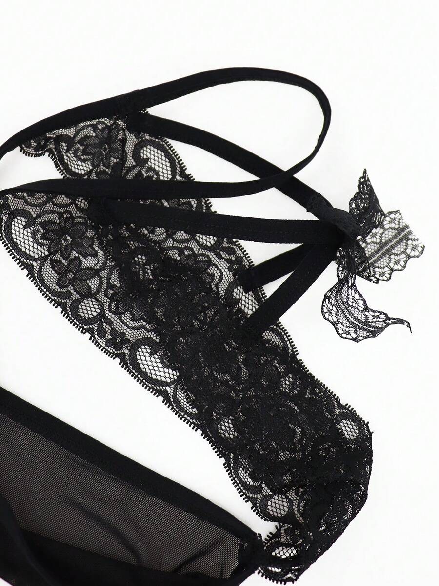 Men's black mesh thong underwear featuring lace trim and bow accent