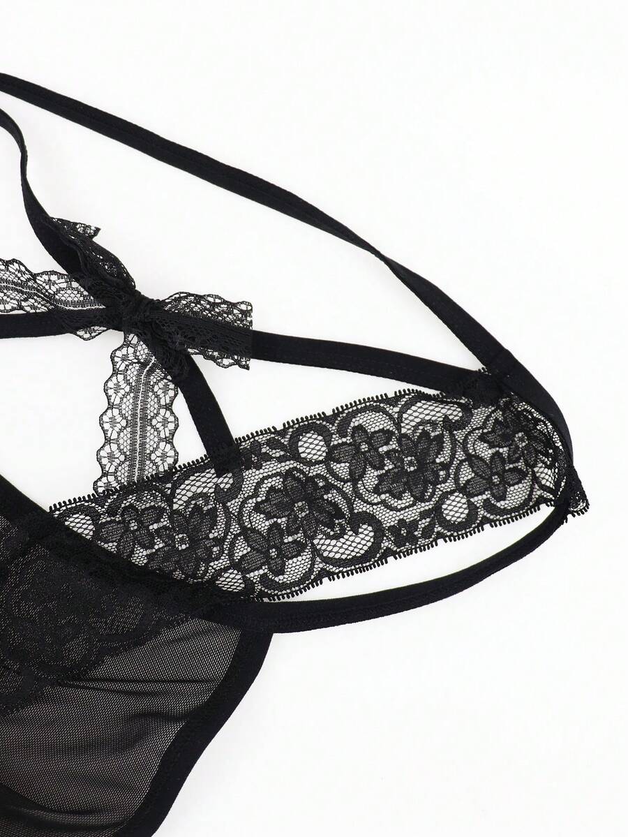 Men's black mesh thong underwear featuring lace trim and bow accent