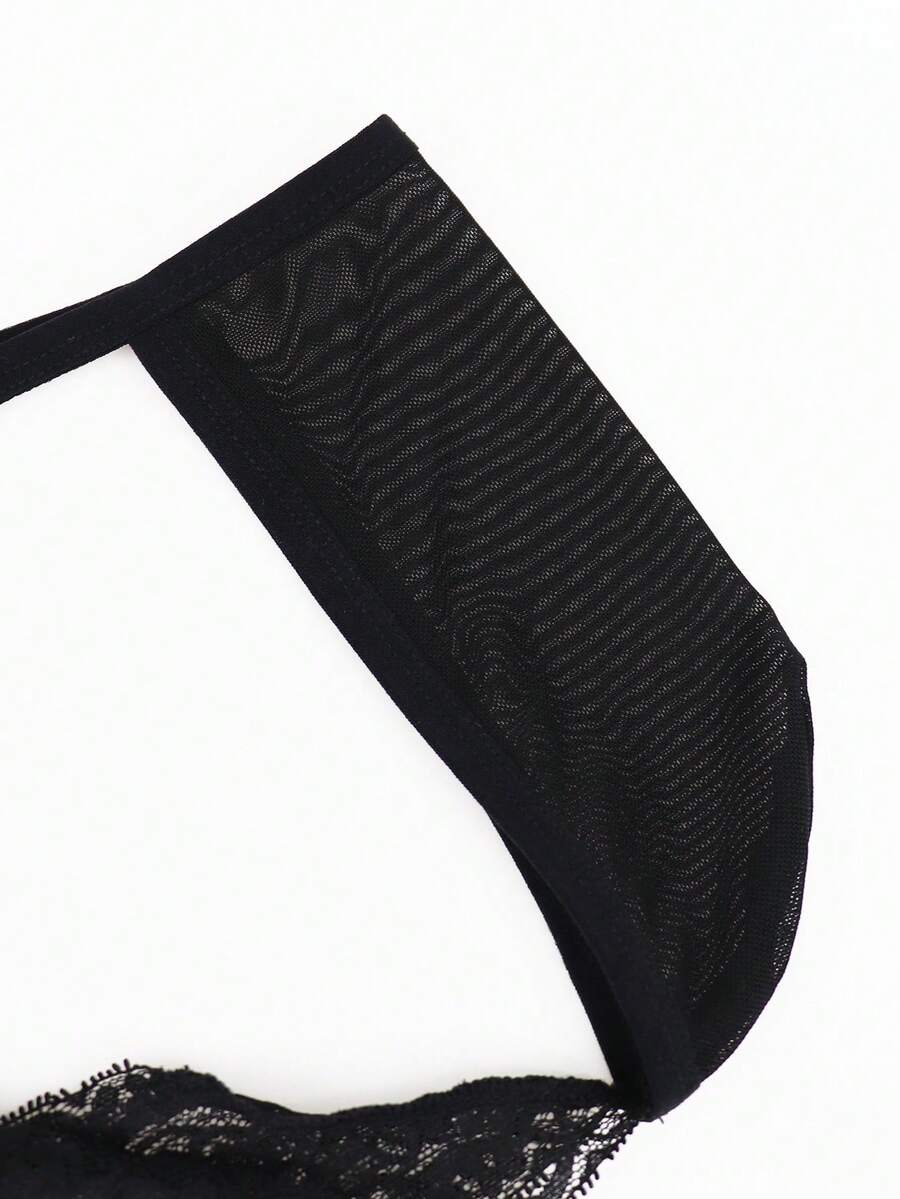 Men's black mesh thong underwear featuring lace trim and bow accent