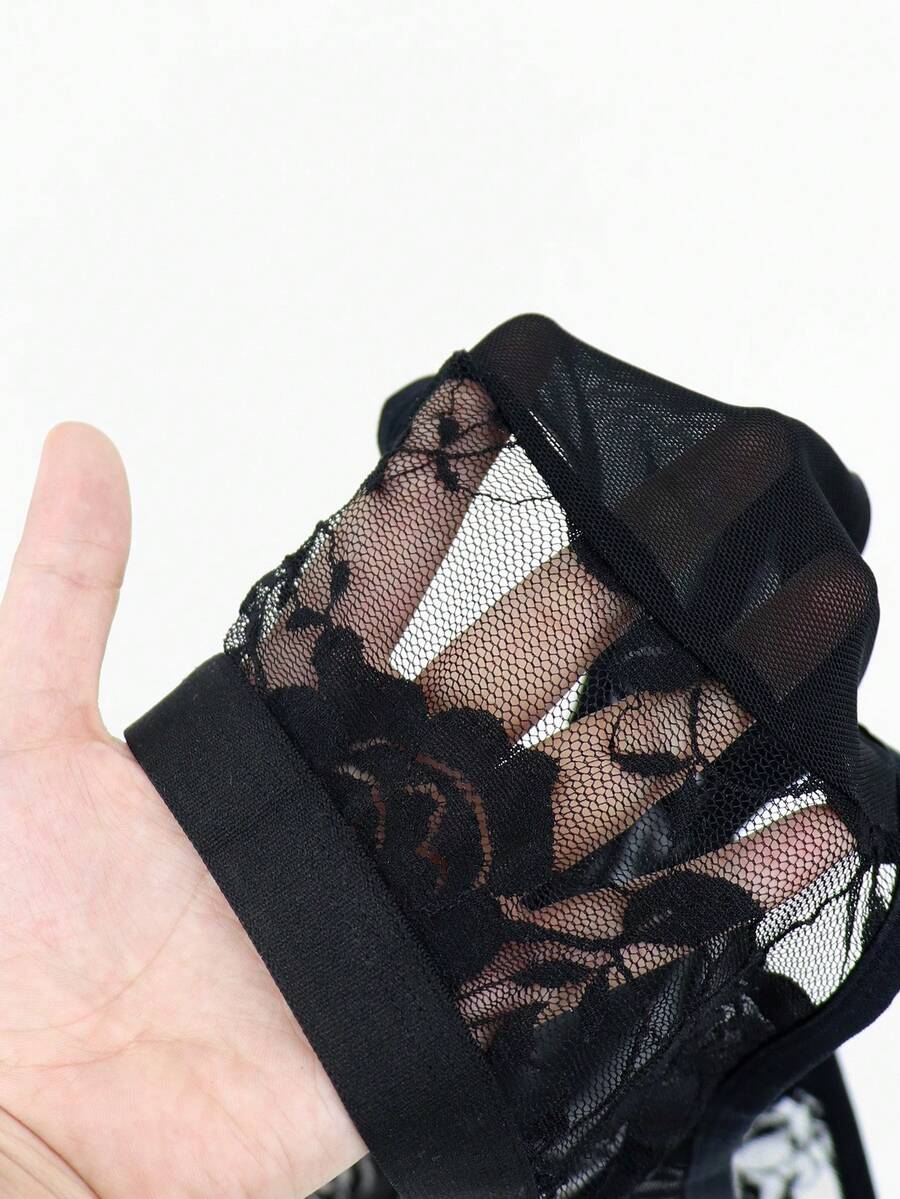 Men's black low rise sheer mesh thong with plant pattern detail.