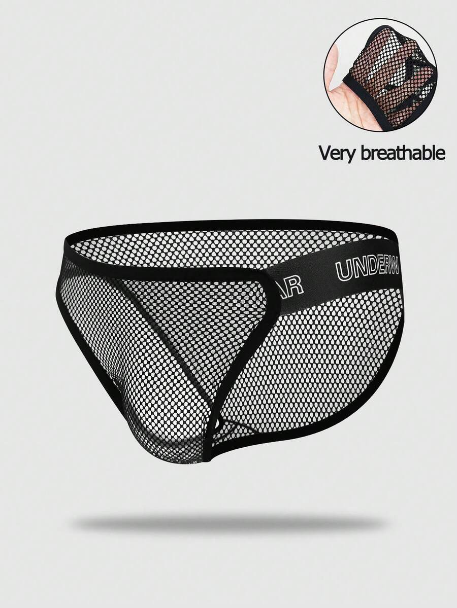 Black men's thong underwear featuring mesh fabric, cut out details, letter pattern, and a low rise fit.